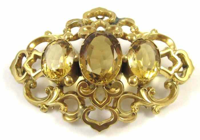 Appraisal: CITRINE AND TEN KARAT GOLD BROOCH set with three oval-cut