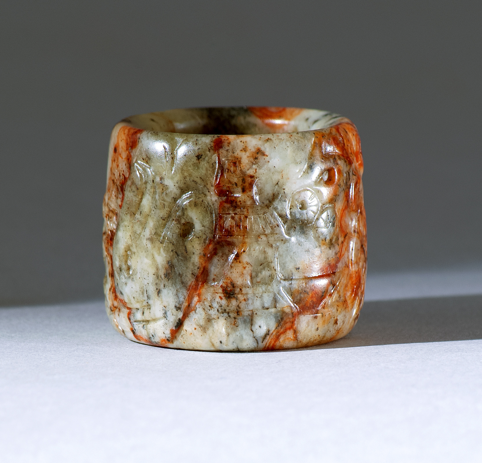 Appraisal: UNUSUAL RED AND BLACK JADE THUMB RING th CenturyWith relief-carved