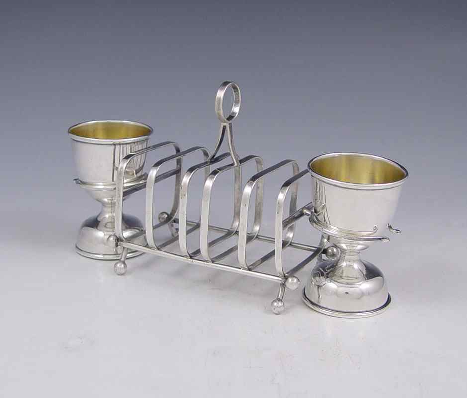 Appraisal: STERLING SILVER TOAST STAND AND EGG CUPS Sterling silver toast