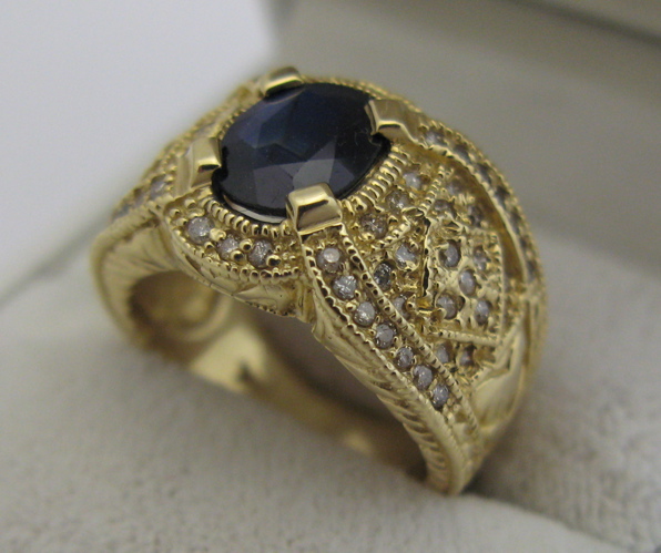 Appraisal: SAPPHIRE DIAMOND AND K GOLD RING centering an oval-cut dark