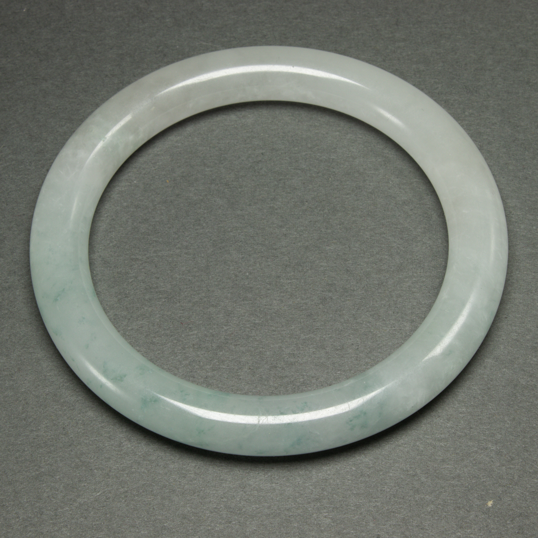 Appraisal: CHINESE JADEITE BANGLE Chinese jadeite bangle of an even semi-translucent