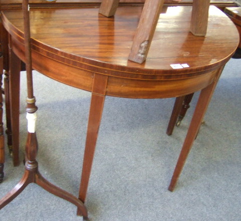 Appraisal: A George III mahogany demi-lune tea table with plain frieze