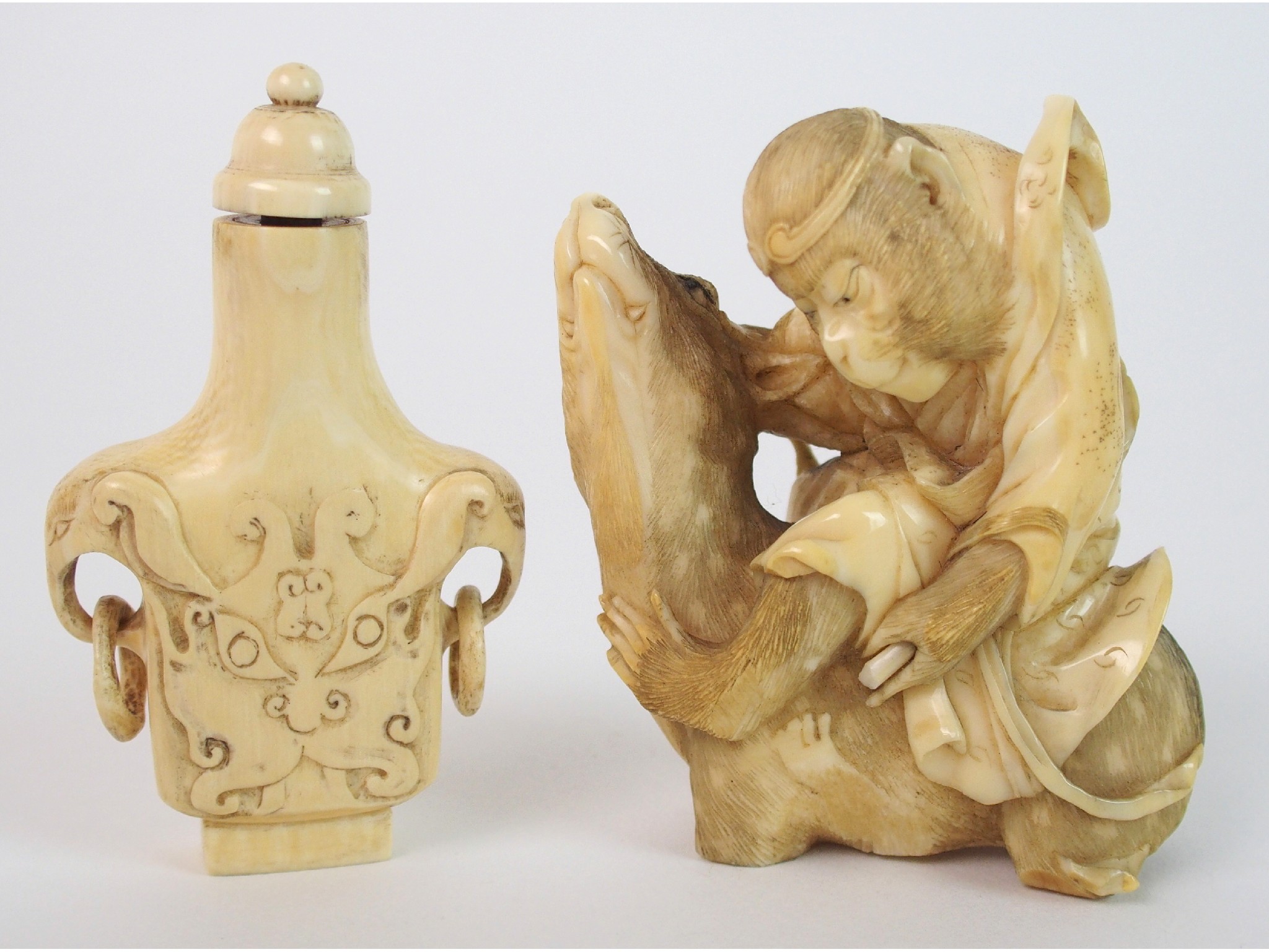 Appraisal: A Japanese ivory okimono of a monkeyseated on a deer