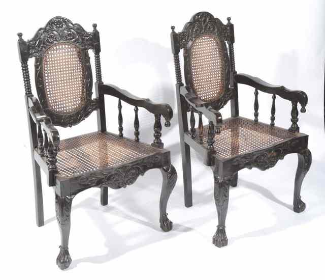 Appraisal: A PAIR OF CEYLONESE EBONY OPEN ARMCHAIRS each with carved