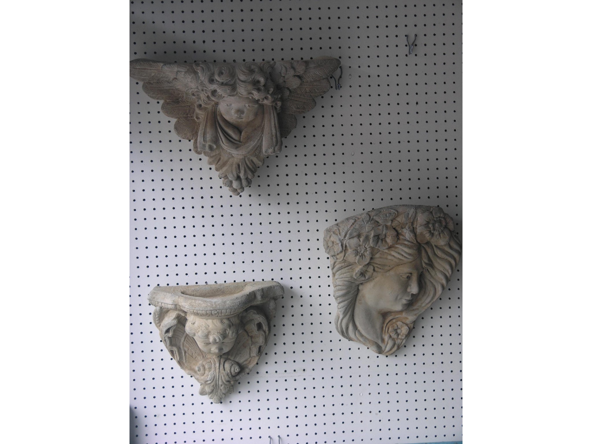 Appraisal: Two moulded concrete wall plaques cherub and young female a