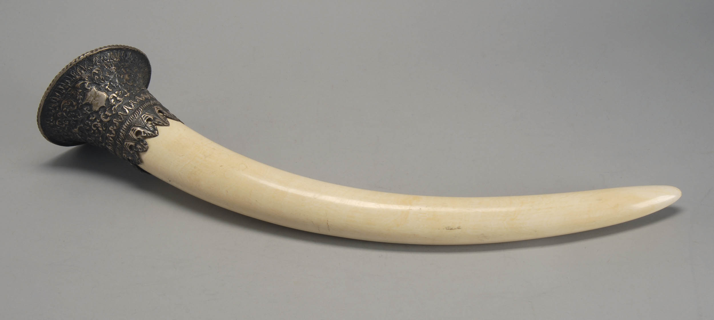 Appraisal: IVORY TRUMPET-FORM VESSEL Indian th CenturyWith silver lion and shield-design