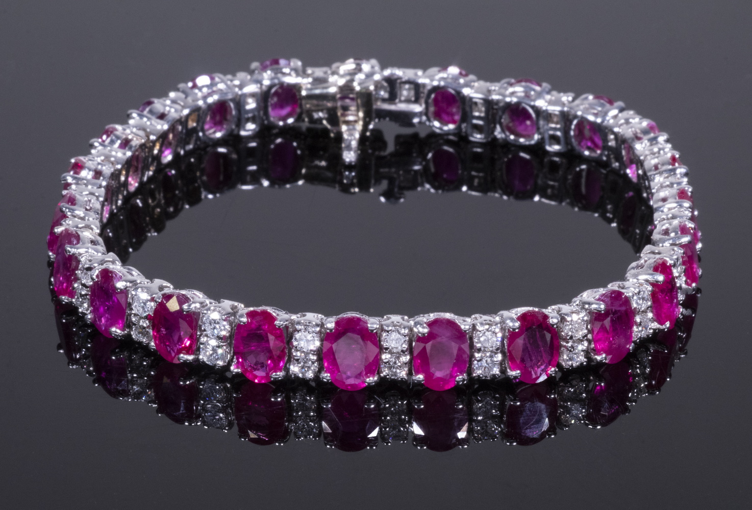 Appraisal: K GOLD RUBY AND DIAMOND LINE BRACELET Set with ct