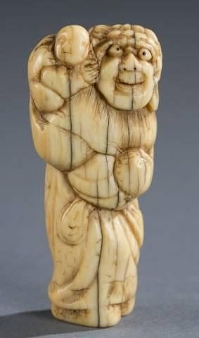 Appraisal: A Japanese ivory netsuke of a man with child A