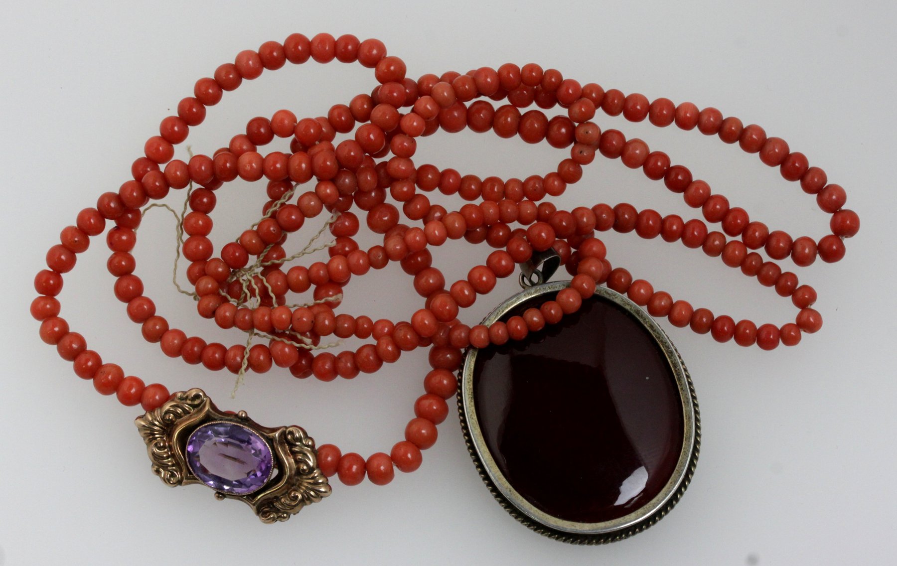 Appraisal: An amethyst brooch a coral bead necklace and a pendant