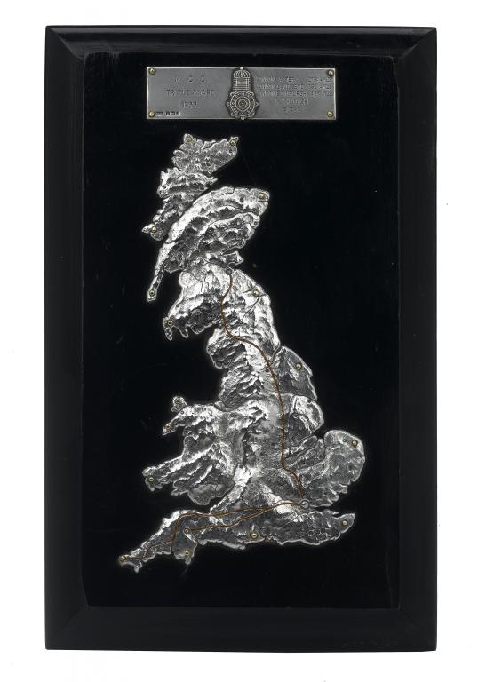 Appraisal: A SILVER-MOUNTED EBONISED WOOD PLAQUE applied with a contoured relief