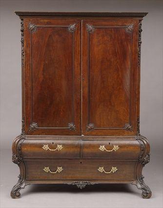 Appraisal: CHIPPENDALE-STYLE CARVED MAHOGANY TWO-PART WARDROBE The dentil-carved cornice above a