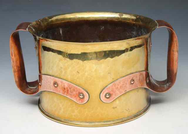 Appraisal: AN ARTS AND CRAFTS BEATEN BRASS AND COPPER TWO HANDLED