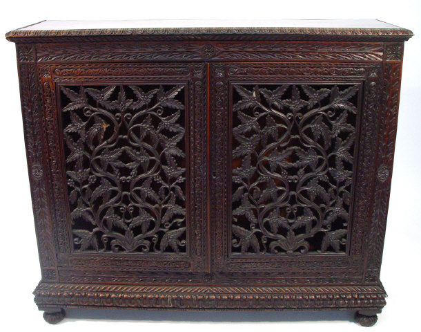 Appraisal: Hardwood bookcase with foliate carved frieze above a pair of