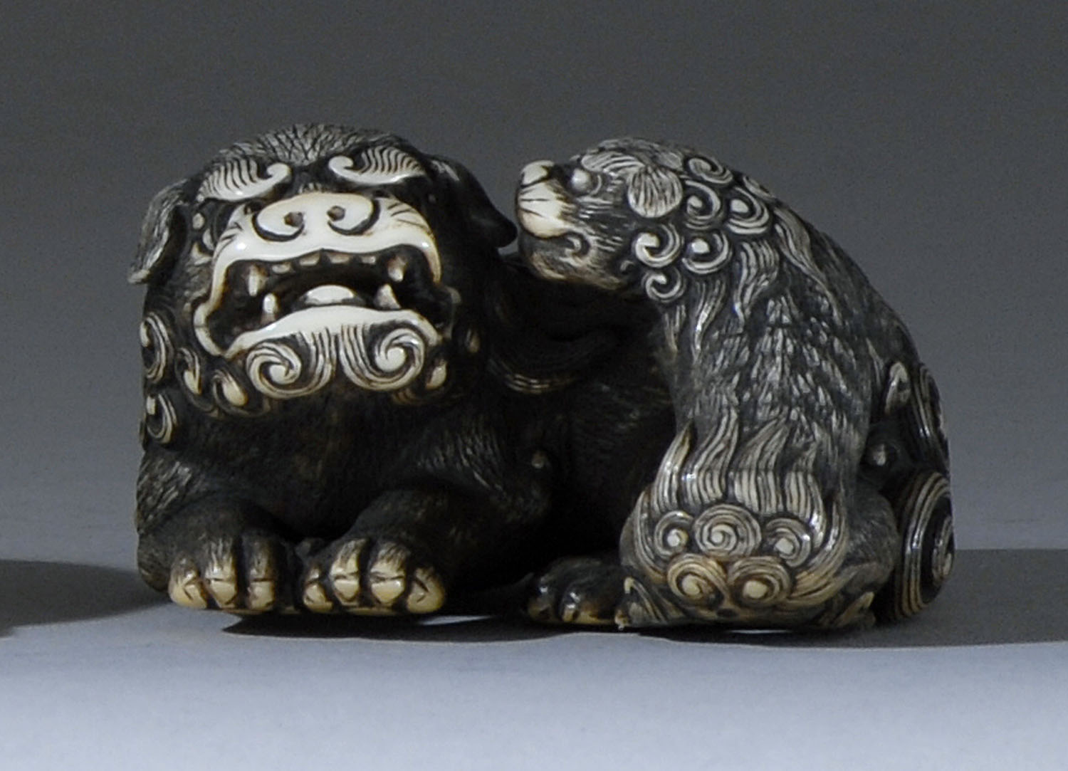 Appraisal: IVORY NETSUKE th CenturyBy Tomotada Depicting a shishi with its