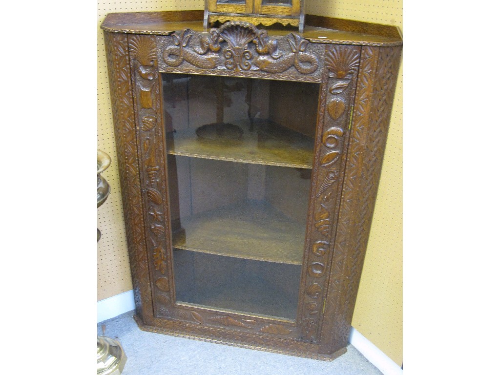 Appraisal: Oak glazed door corner cabinet carved with stylised fish conches