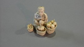 Appraisal: A Japanese carved ivory figure of a street vendor with