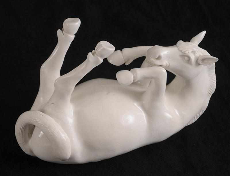 Appraisal: CHINESE IVORY-GLAZED PORCELAIN FIGURE OF A HORSE Modeled lying on