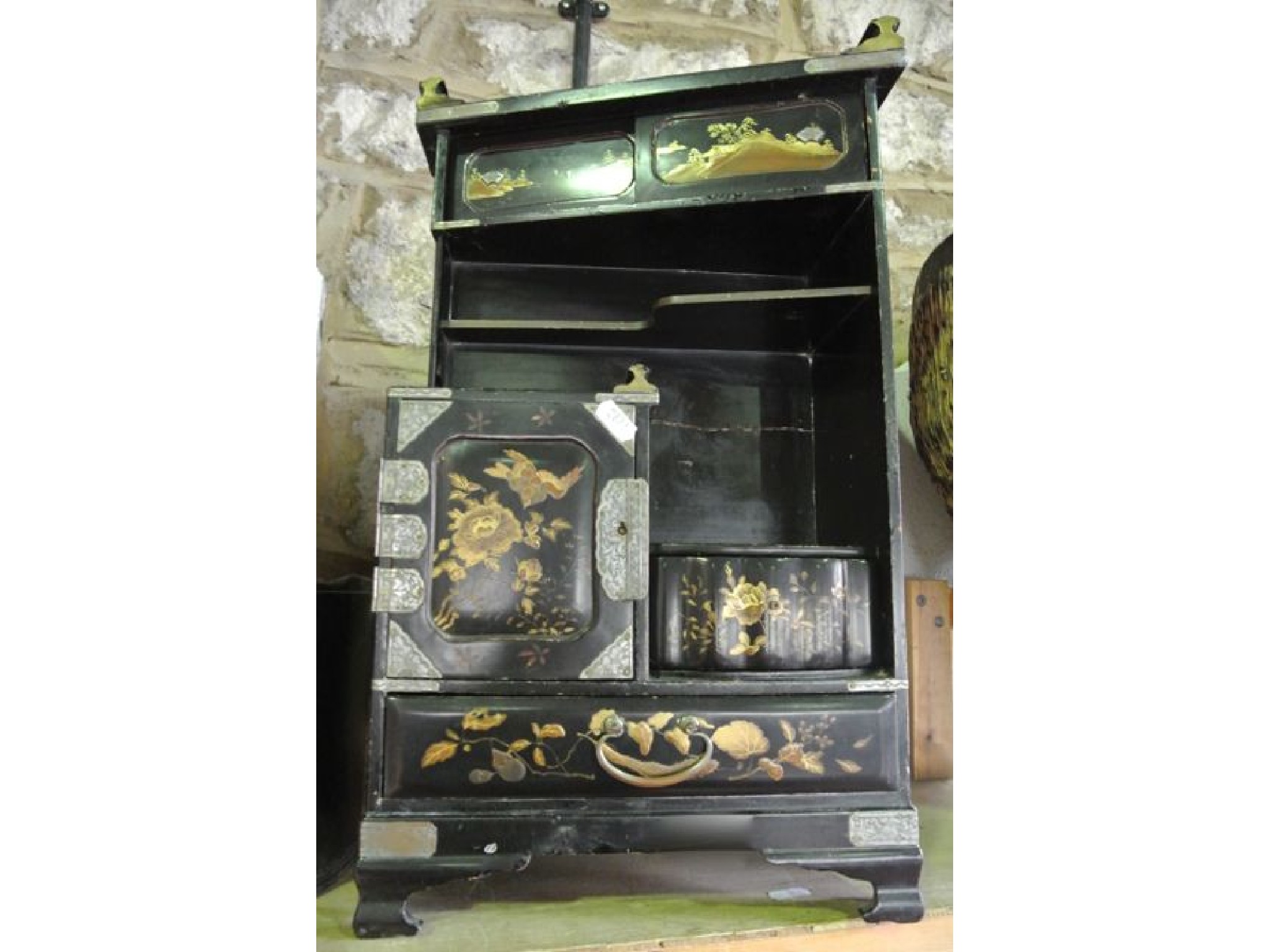 Appraisal: A black lacquered miniature cabinet with an arrangement of two