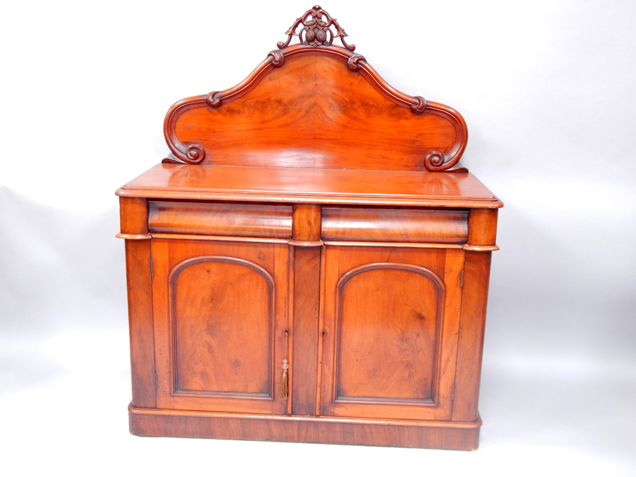 Appraisal: A Victorian mahogany chiffonier shaped back over a cushion drawer