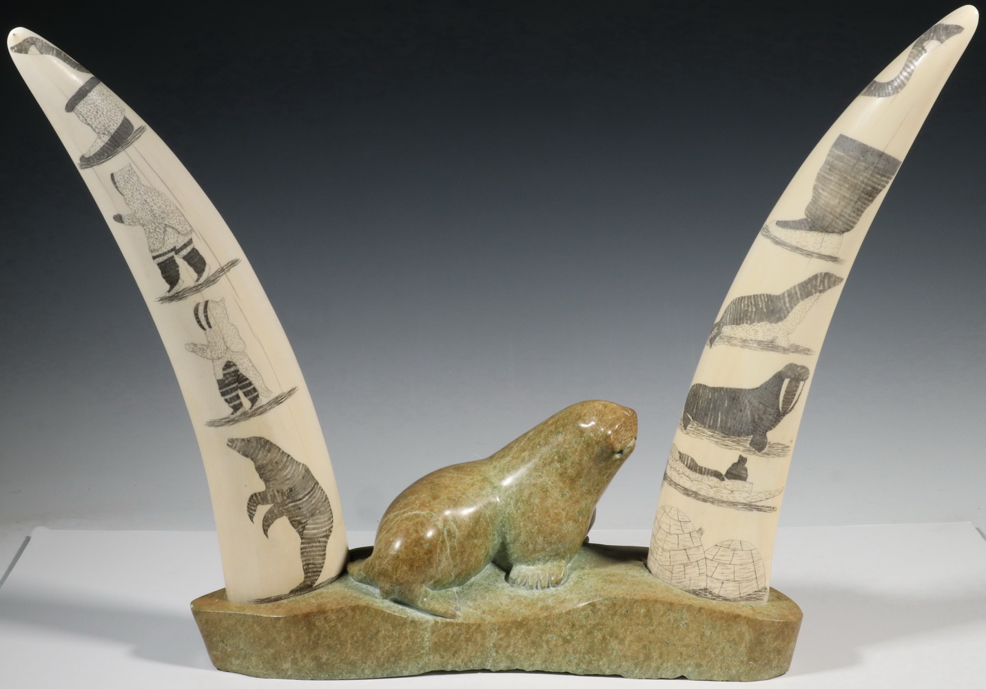 Appraisal: INUIT SCULPTURE OF SOAPSTONE WITH SCRIMSHAWN WALRUS TUSKS UNSIGNED NORTHERN