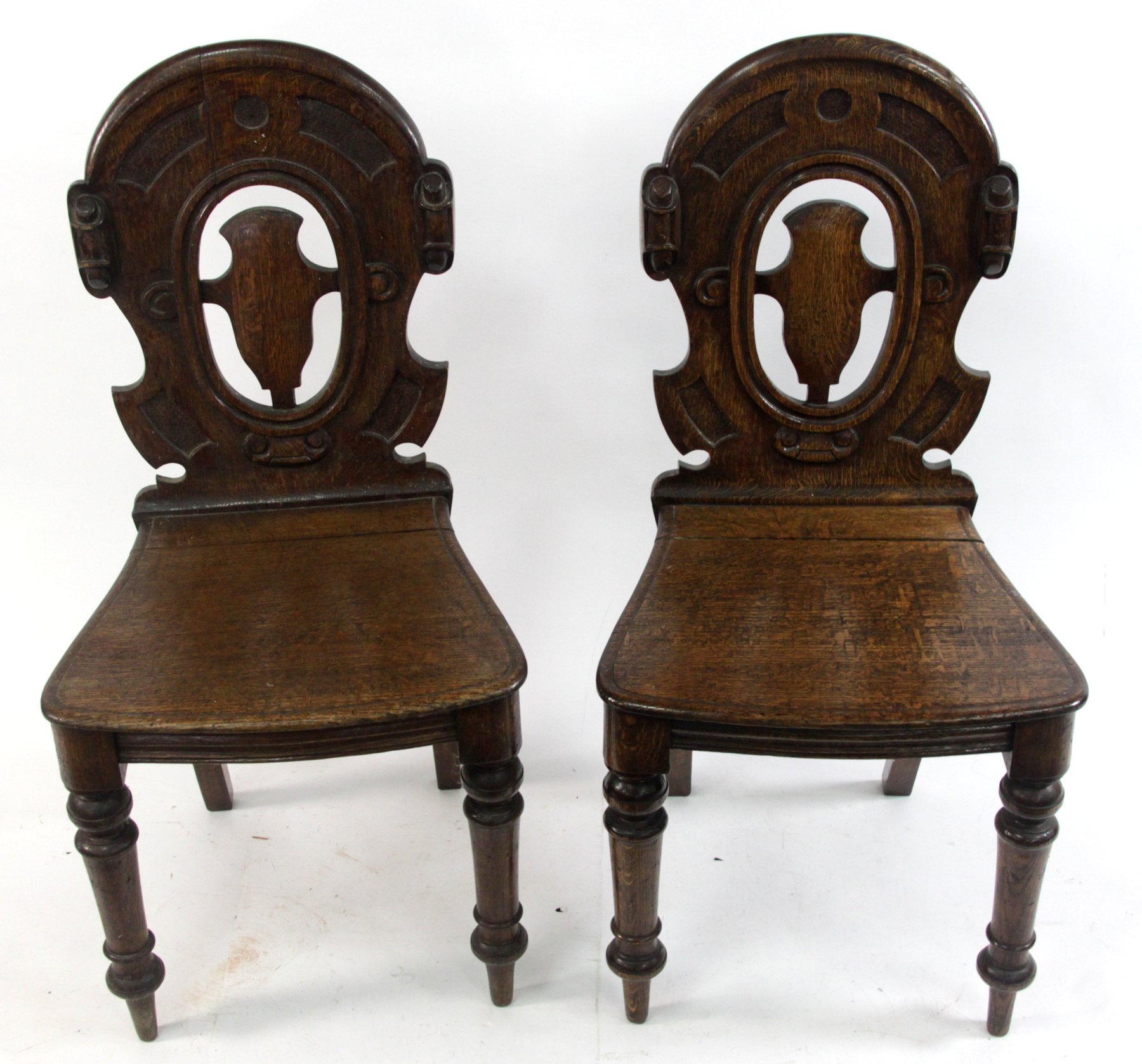 Appraisal: A pair of Victorian oak hall chairs with pierced backs