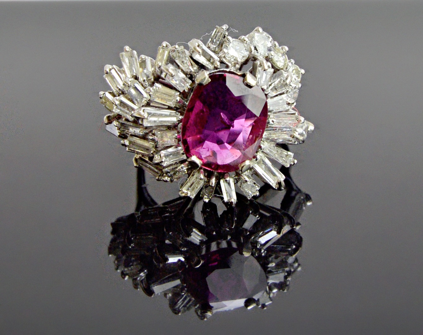 Appraisal: A magenta sapphire and diamond set cluster ring claw set