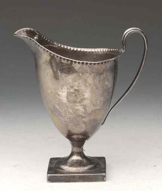 Appraisal: A GEORGE III SILVER HELMET JUG standing on a square