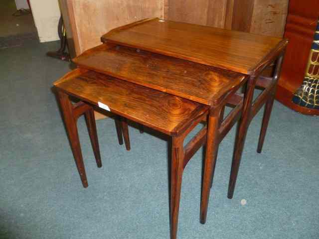 Appraisal: TWO NESTS OF THREE STYLISED ROSEWOOD OCCASIONAL TABLES together with