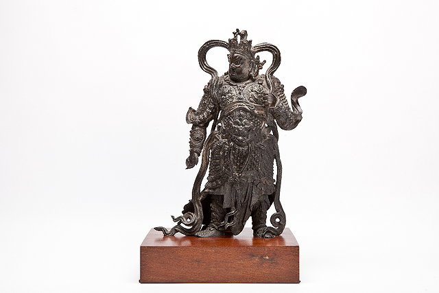 Appraisal: A CHINESE BRONZE SCULPTURE OF A BUDDHIST GUARDIAN in warrior