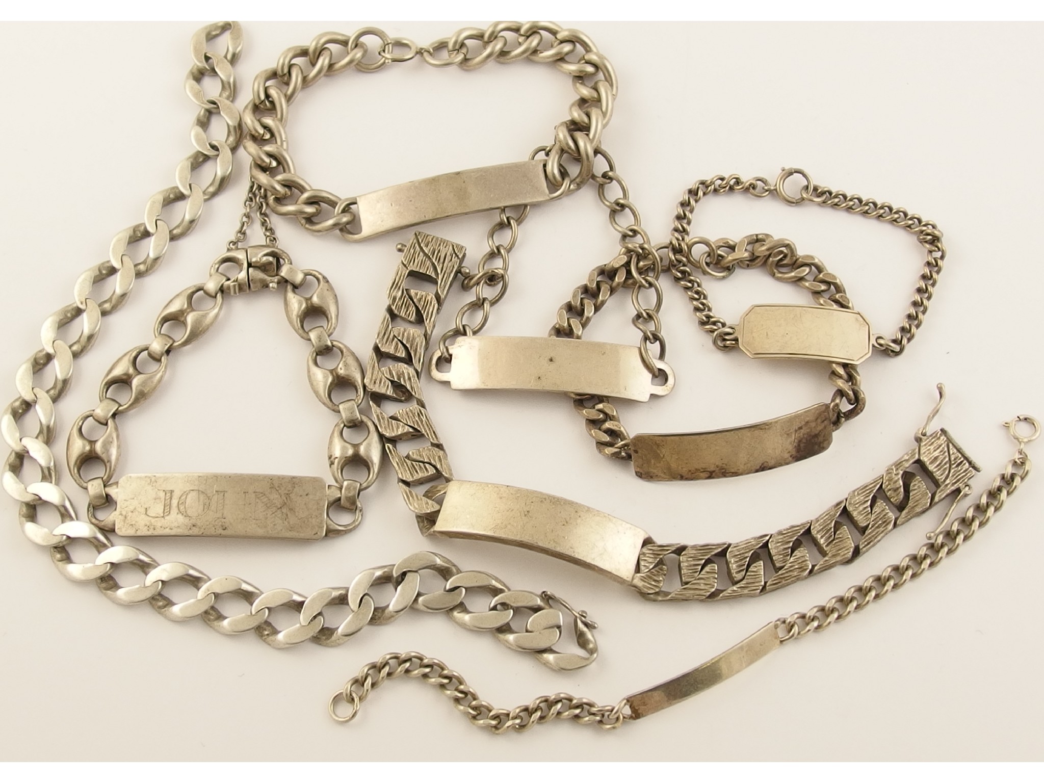 Appraisal: A collection of silver and white metal ID bracelets and