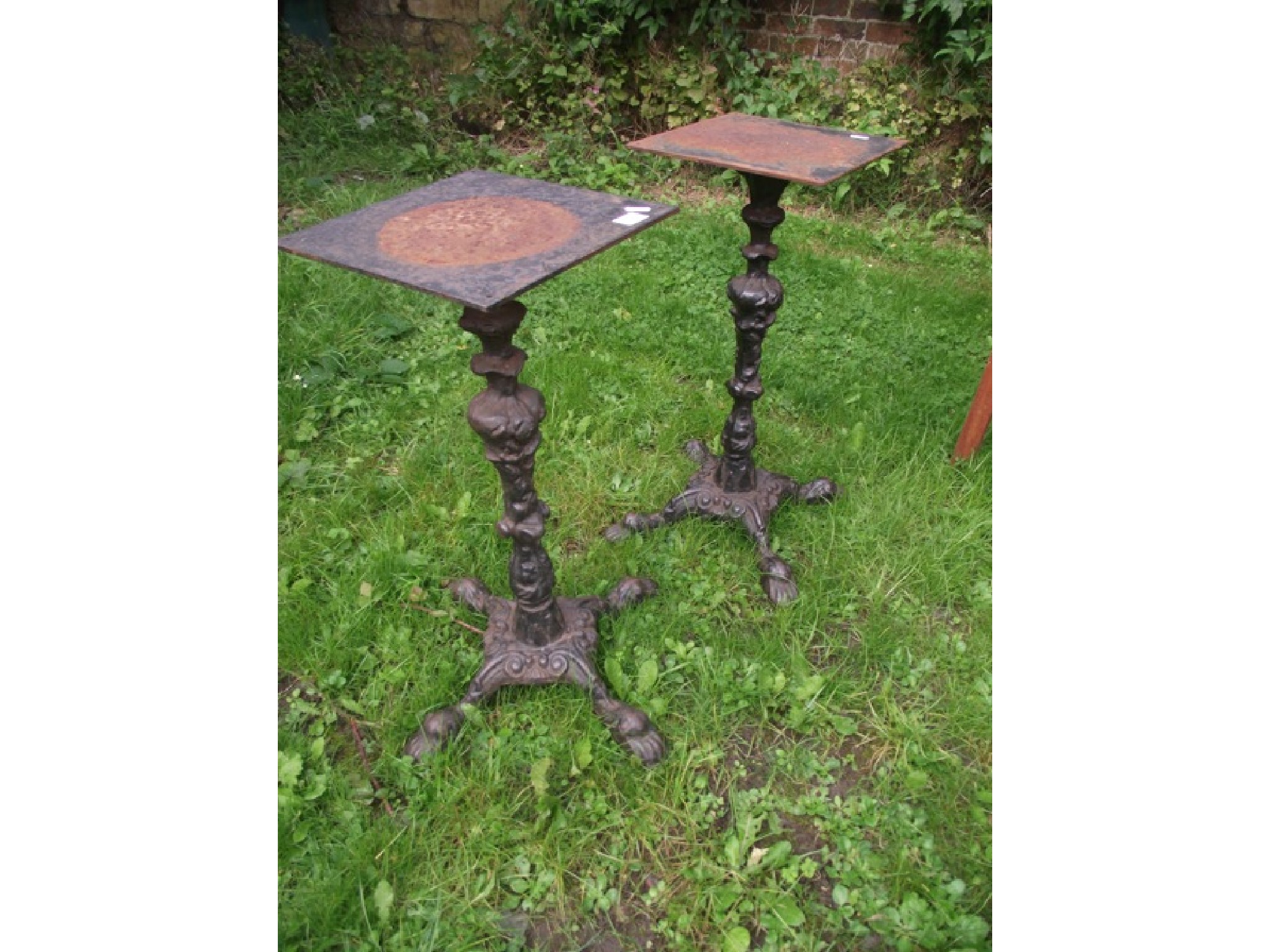 Appraisal: A pair of cast iron table stands on lions paw