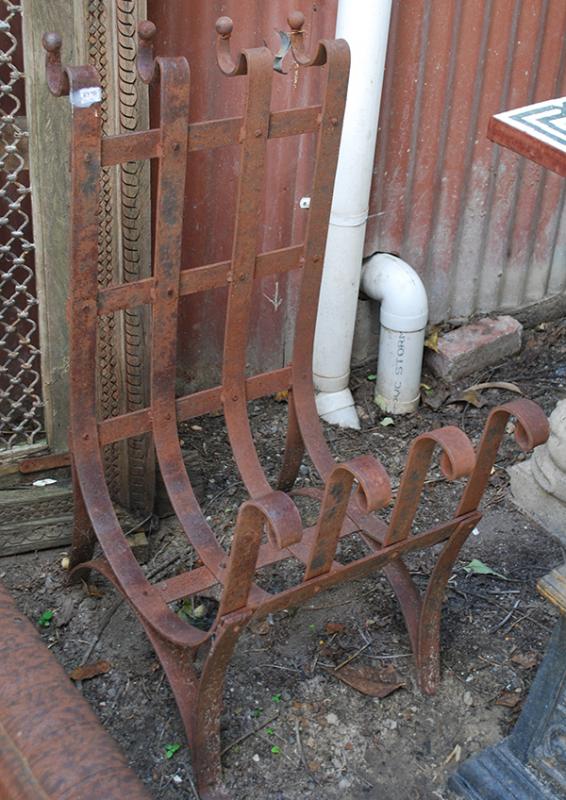 Appraisal: A WROUGHT IRON FIREWOOD STAND with a curved openwork body