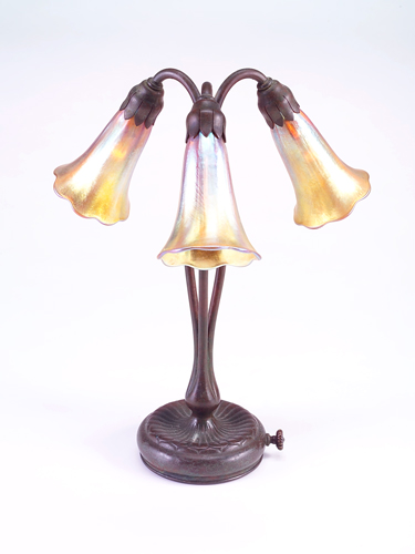 Appraisal: TIFFANY STUDIOS Three-lily table lamp with patinated bronze base and