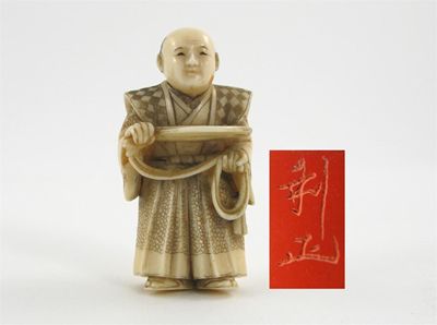 Appraisal: A Japanese ivory netsuke carved as a man holding a