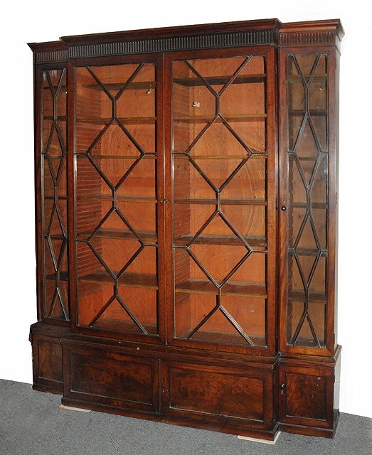 Appraisal: A TH CENTURY MAHOGANY BREAKFRONT LIBRARY BOOKCASE with cupboards below