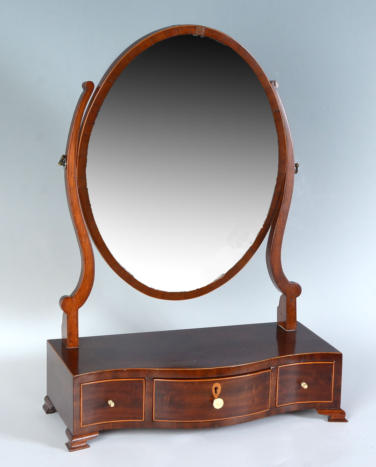 Appraisal: TH C MAHOGANY SHAVING MIRROR Circa Georgian serpentine front Mahogany