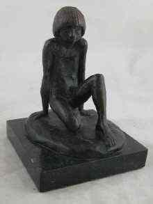 Appraisal: A bronze figure of a naked boy sitting on one