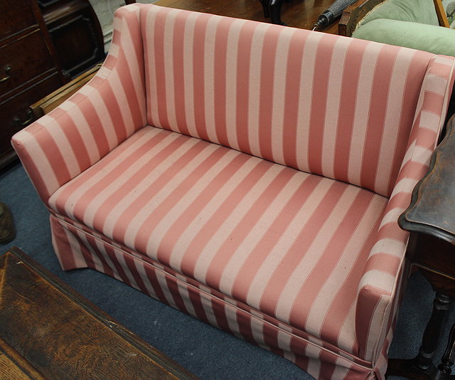 Appraisal: A SMALL EDWARDIAN TWO SEATER SOFA with pink striped upholstery