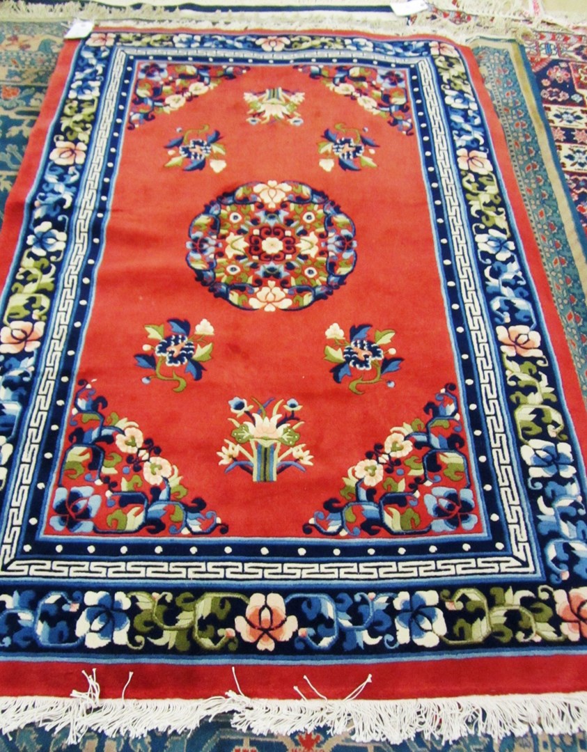 Appraisal: A Chinese rug the red field with floral roundel spandrels