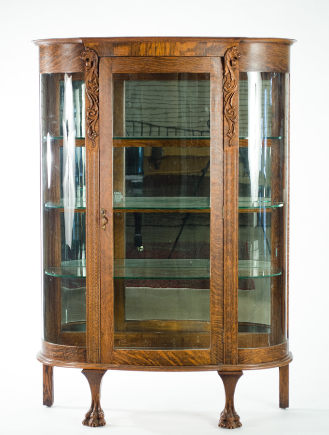 Appraisal: CARVED OAK AND CURVED GLASS CHINA DISPLAY CABINET American c