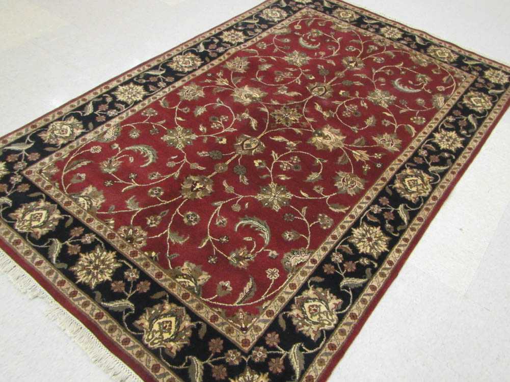 Appraisal: HAND KNOTTED ORIENTAL CARPET Indo-Persian floral vine motif on madder