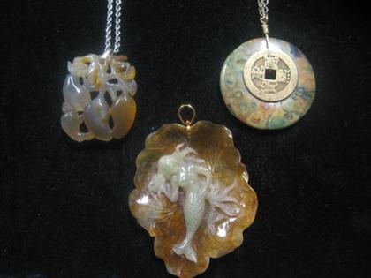 Appraisal: Group of brown jade and hard stone pendants Three pieces