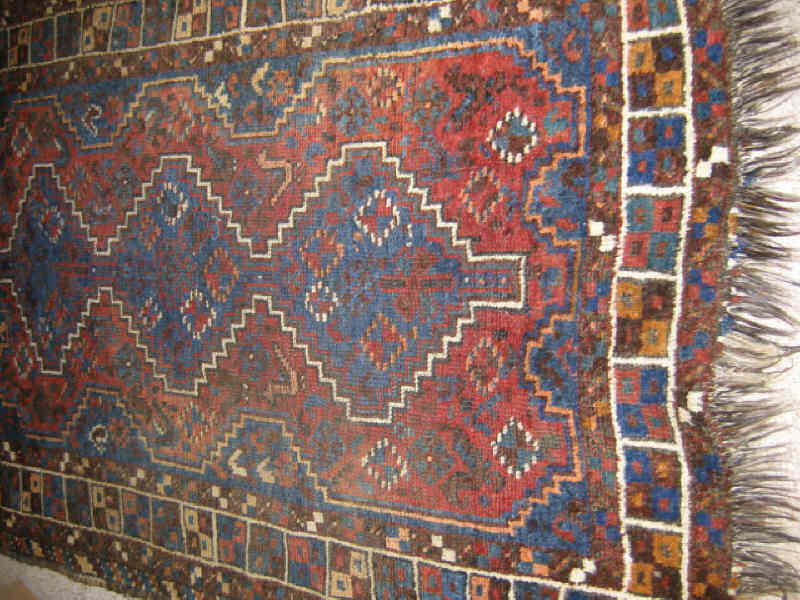 Appraisal: SHIRAZ THROW RUG The red field of geometric animal and