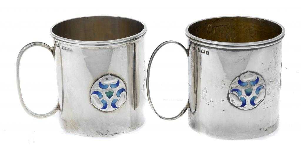 Appraisal: TWO SIMILAR ARTS CRAFTS MOVEMENT SILVER AND ENAMEL CHRISTENING MUGS