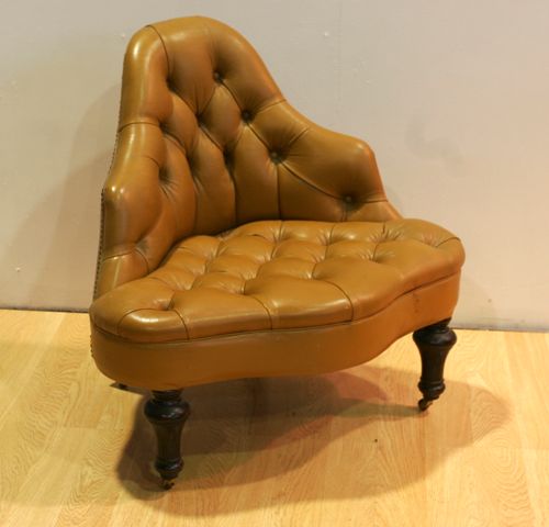 Appraisal: An unusual tan leather button backed corner chair retailed by