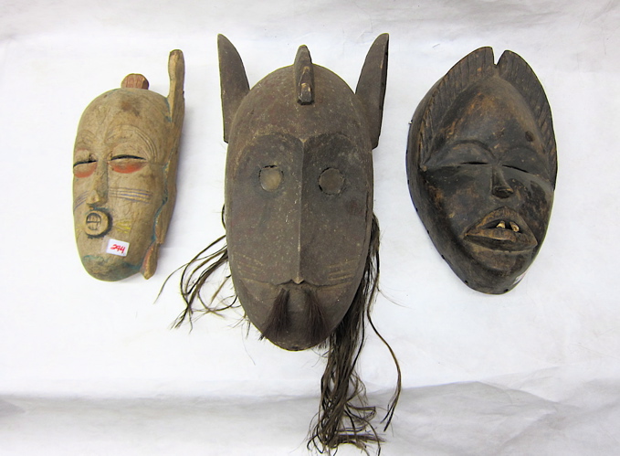 Appraisal: THREE WOOD CARVED AFRICAN MASKS of animal and human forms