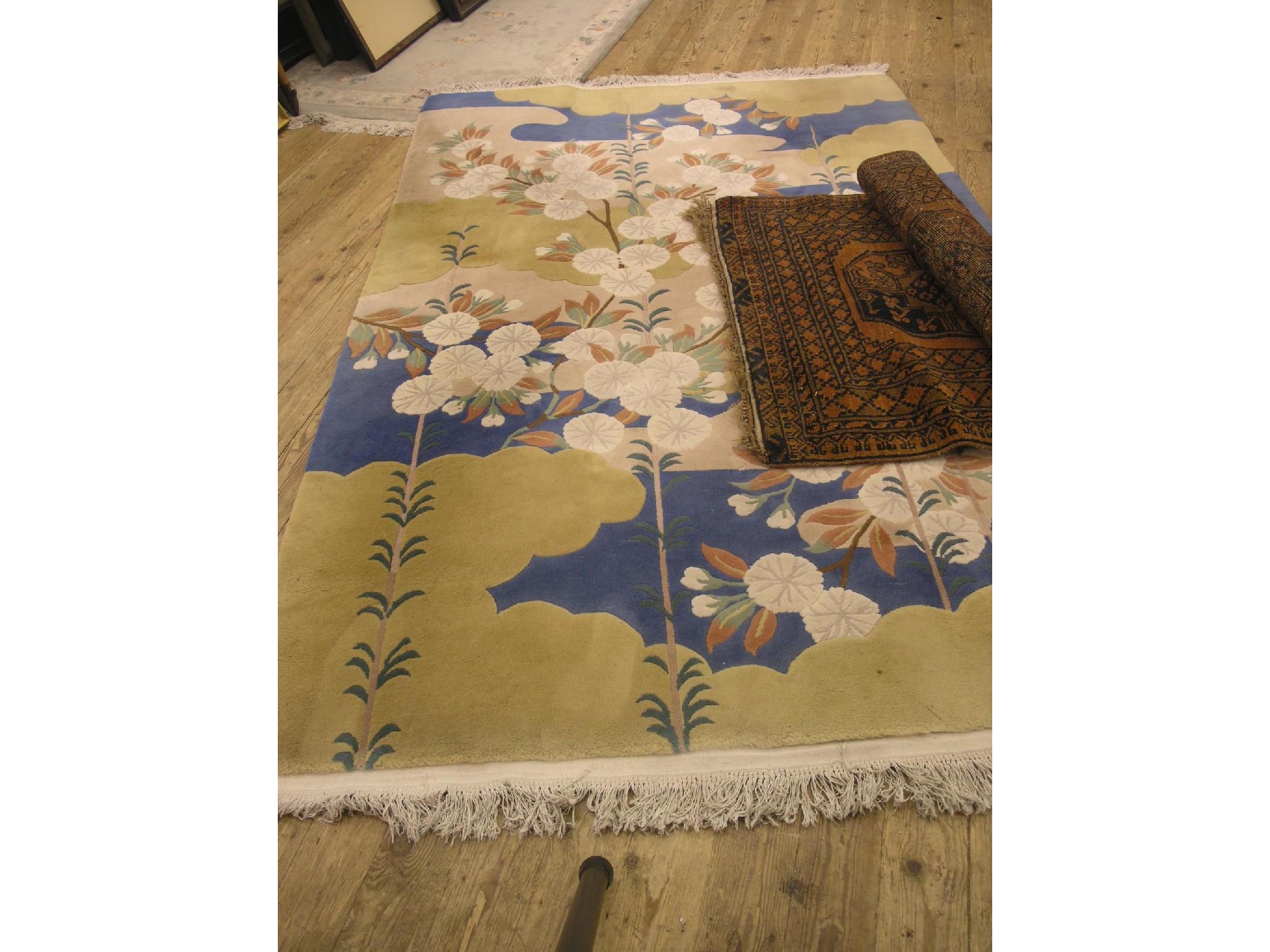 Appraisal: An Eastern wool rug floral design against a three-colour ground