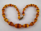 Appraisal: An amber necklace the beads with dark amber sections largest