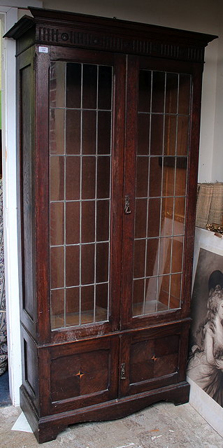 Appraisal: AN EDWARDIAN OAK DISPLAY CABINET with lead glazed doors further