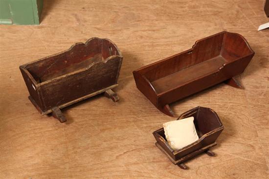 Appraisal: THREE WOODEN DOLL CRADLES Two with brown paint h w